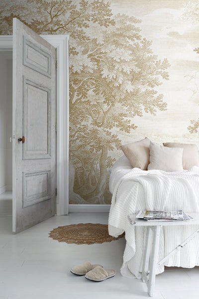 Helles Schlafzimmer mit Baumtapete und offen stehender Tür