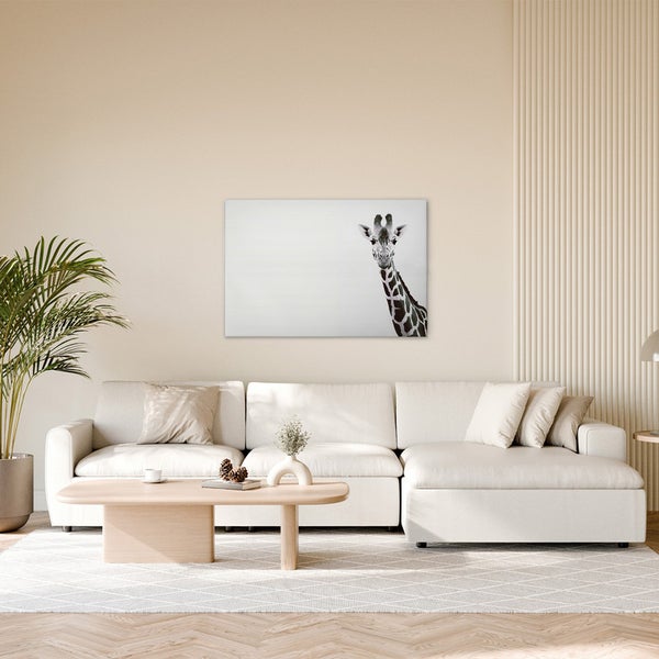 Wohnzimmer mit Sofa, Tisch und einem Bild einer Giraffe an der Wand.