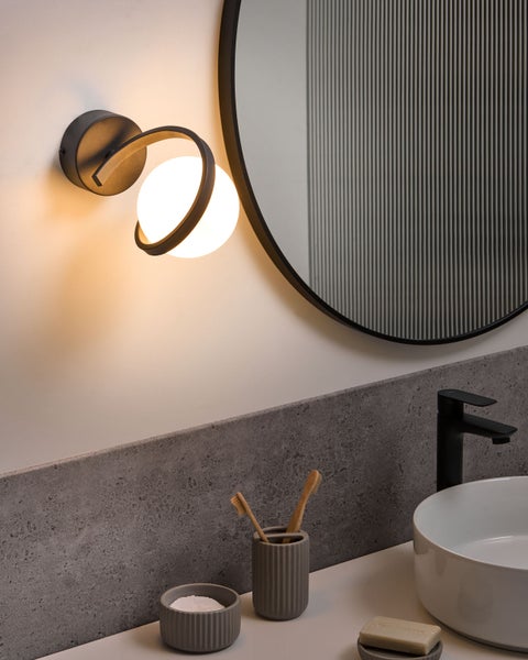 Modernes Badezimmer mit Wandleuchte, Spiegel und Waschbecken