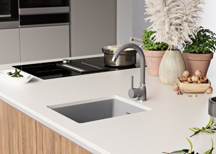 Küchenszene mit Spüle, Armatur, Kochfeld, Topf, Pflanzen und Dekoration