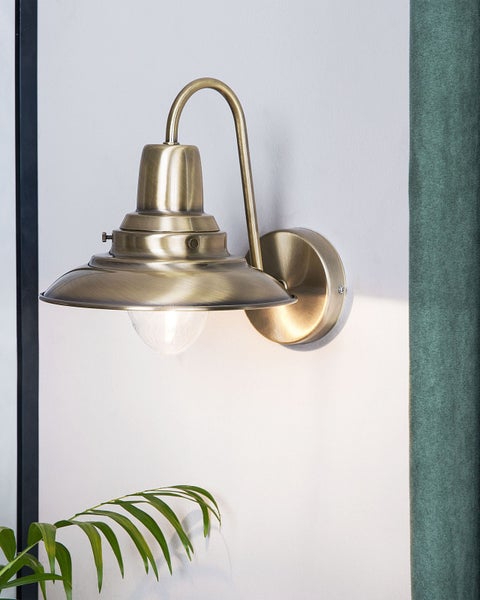 Messingfarbene Wandleuchte mit Lampenschirm und klarem Glas