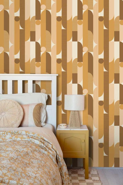 Vliestapete mit retro-geometrischem Muster aus Bögen und Kreisen in Erdtönen, im Schlafzimmer mit weißem Bett und Beistelltisch.