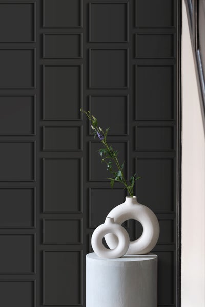 Dekorative Wandgestaltung mit Paneelen und zwei Keramikvasen auf einem Sockel