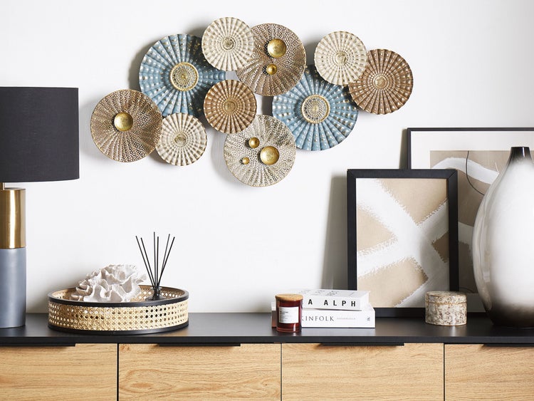 Dekorative Wandkunst mit Lampenfuß, Bilderrahmen, Duftstäbchen und verschiedenen dekorativen Gegenständen auf einem Holzschrank