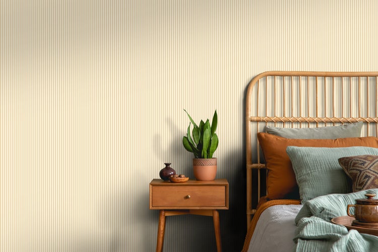 Schlafzimmer mit gestreifter Tapete, Rattankopfteil und Nachttisch