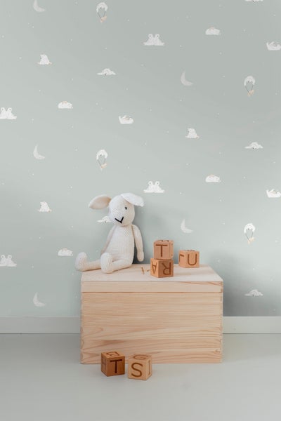 Kinderzimmer mit Spielzeug und einer Kiste vor einer Wandtapete mit Bärenmotiven