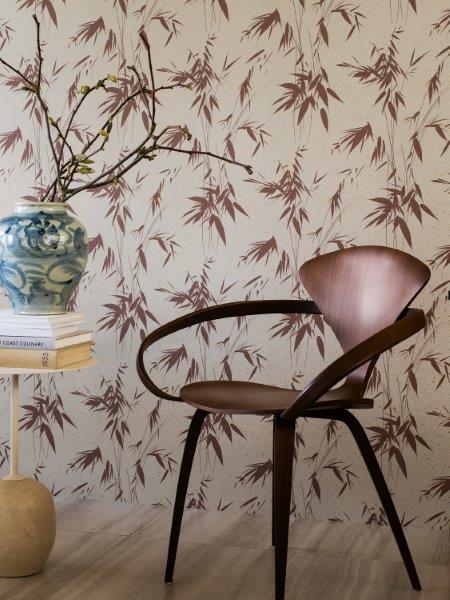 Dekoratives Wohnambiente mit gemusterter Tapete, Beistelltisch und Zimmerpflanze