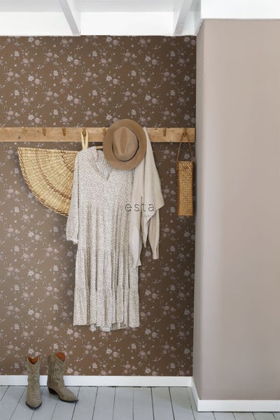 Raumansicht mit geblümter Tapete, Garderobe mit Kleid, Hut, Strickjacke und Dekorationen