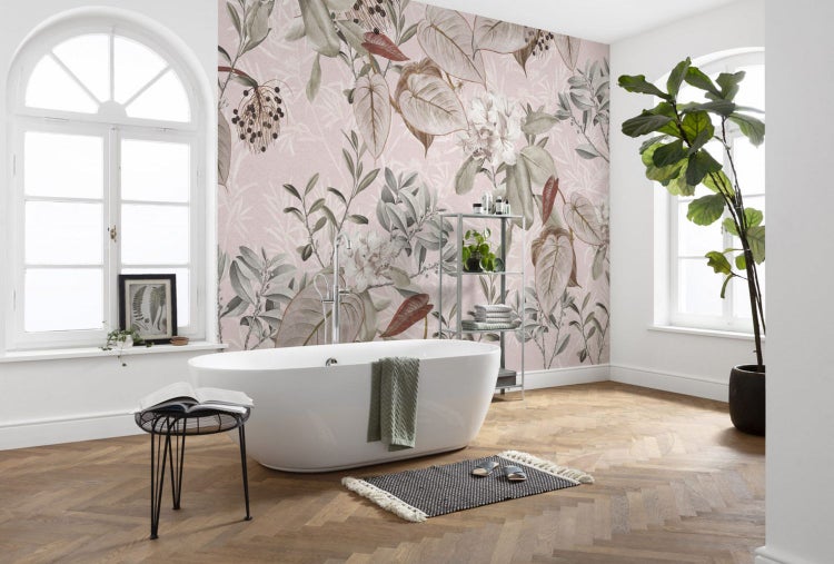 Badezimmer mit floraler Tapete, Badewanne und Zimmerpflanze für eine helle und freundliche Atmosphäre.