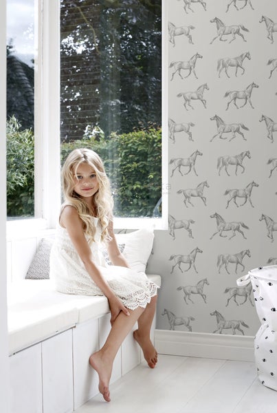 Helles Zimmer mit Fensterbank, Mädchen und Tapete mit Pferdemuster
