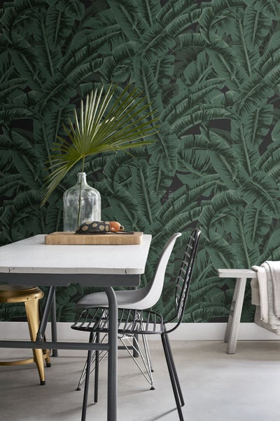 Esszimmer mit Esstisch, Stühlen und Tapete mit Bananenblattmuster für eine stilvolle Atmosphäre.