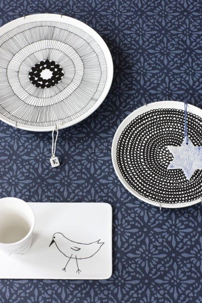 Dekorative Teller mit Vogelmotiv und Anhänger auf einem Tisch