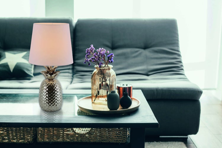 Dekorative Szene mit einer Ananas-Tischleuchte, einer Vase mit Blumen und dekorativen Vasen auf einem Tisch