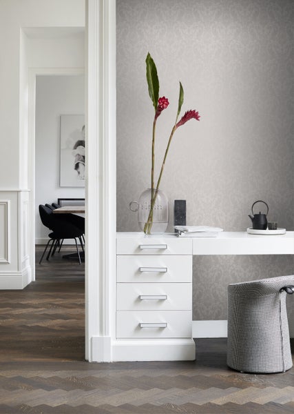 Innenraum mit gemusterter Tapete, weißem Schreibtisch und Holzfußboden