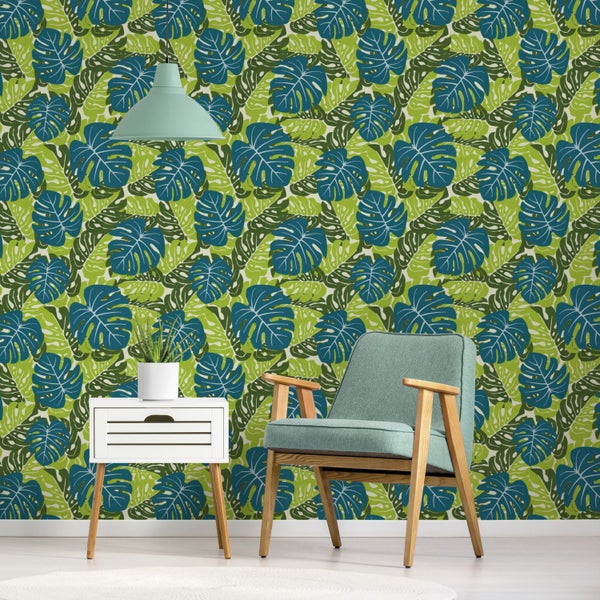 Dekoratives Interieur mit einem Sessel, einem Nachttisch, einer Zimmerpflanze und einer grünen Blättertapete