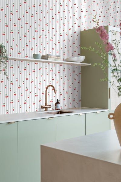 Schlafzimmer mit floraler Tapete, Bett, Nachttisch und Lampe