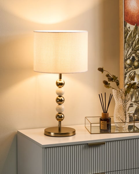 Dekorative Tischleuchte mit Lampenschirm auf Kommode