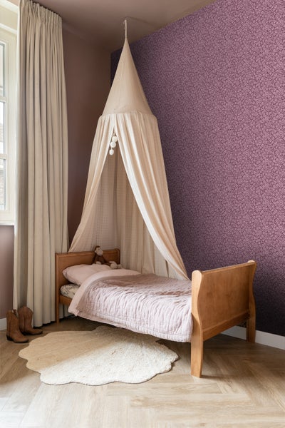 Kinderzimmer mit Himmelbett, Teppich und gemusterter Tapete