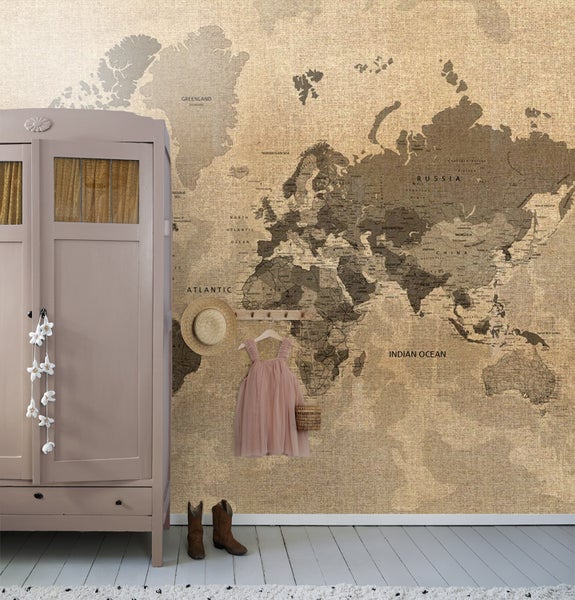 Zimmer mit Wandtapete einer Weltkarte, Kleiderschrank, Kinderkleidung und Accessoires.