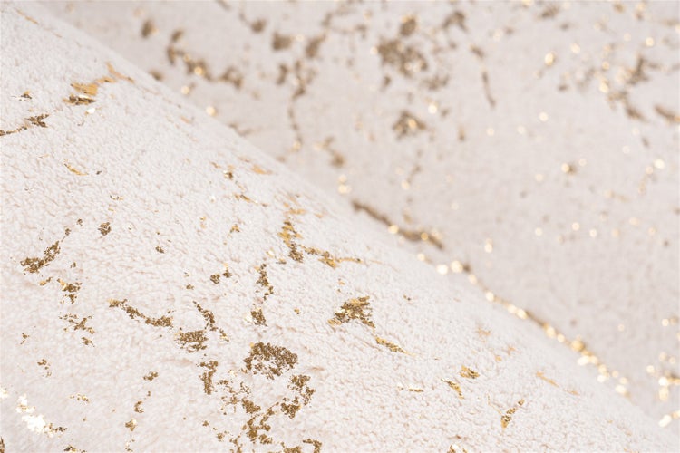 Nahaufnahme eines weichen Hochflor-Teppichs mit goldenem Marmormuster.