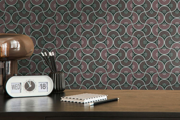 Schlafzimmer mit Bett, Beistelltisch, Lampe und gemusterter Tapete