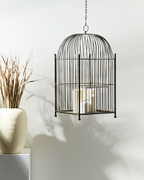 Dekorative Hängeleuchte in Vogelkäfigform mit Kerzen und einer Vase mit trockenem Gras