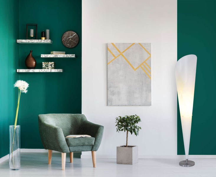 Wohnzimmer mit Sessel, Stehlampe, Wandregalen und Kunstwerken für eine stilvolle Einrichtung.