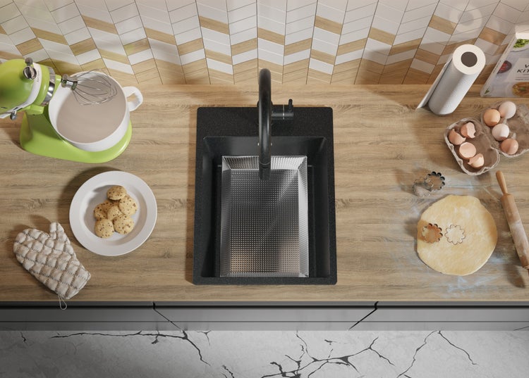 Küchenszene mit Spüle, Armatur, Rührgerät, Keksen, Eiern und Backutensilien auf einer Arbeitsplatte