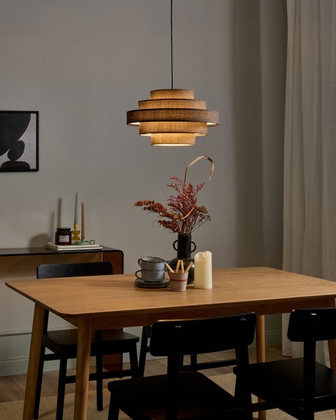 Esstisch-Szene mit hölzernem Tisch, schwarzen Stühlen und mehrstufiger Hängeleuchte