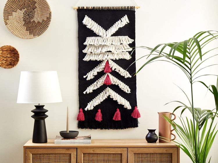 Wohnzimmerdekoration mit Wandteppich, Tischlampe und Rattankorb