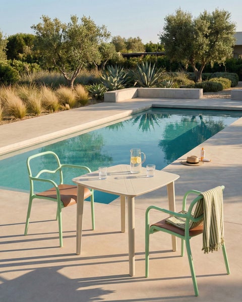 Szene mit Gartentisch und Stühlen neben einem Swimmingpool