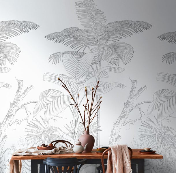 Dekoratives Zimmer mit einer Wandtapete mit Dschungelmotiven hinter einem Esstisch