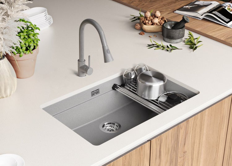 Küchenspüle mit Abtropfgestell und Armatur auf einer Küchentheke