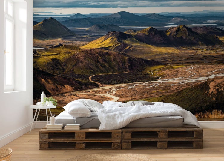 Wandbild mit Berglandschaft hinter einem Bett auf Paletten