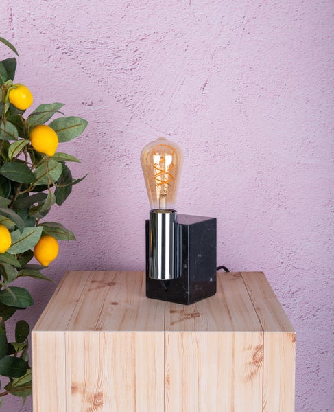 Tischleuchte mit Marmorfuß und Edison-Glühbirne auf einem Tisch