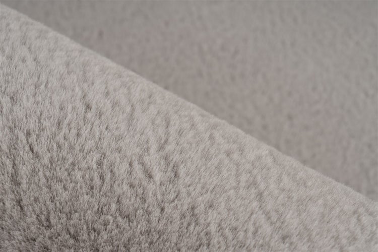 Nahaufnahme eines weichen, grauen Kunstfellstoffs mit dichter und flauschiger Textur.