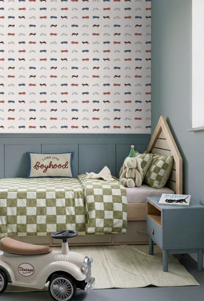Vliestapete mit kleinen Vintage-Rennwagen in einer Kinderzimmer-Szene mit grünem Schrank, Garderobe und Spielzeug auf Holzboden.