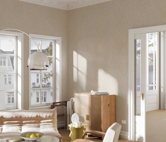 Helles Wohnzimmer mit Sofa, Schrank, Fenstern und Pendelleuchte.