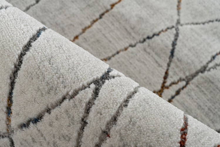 Nahaufnahme eines Teppichs mit strukturiertem Flor und einem Muster aus dünnen wellenförmigen Linien.