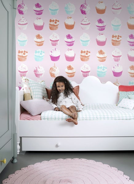 Szene mit einer Tapete mit Cupcake-Motiv und einem weißen, antiken Schrank