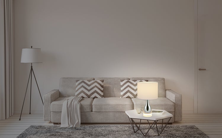 Wohnzimmer mit Sofa, Stehlampe und Tischlampe