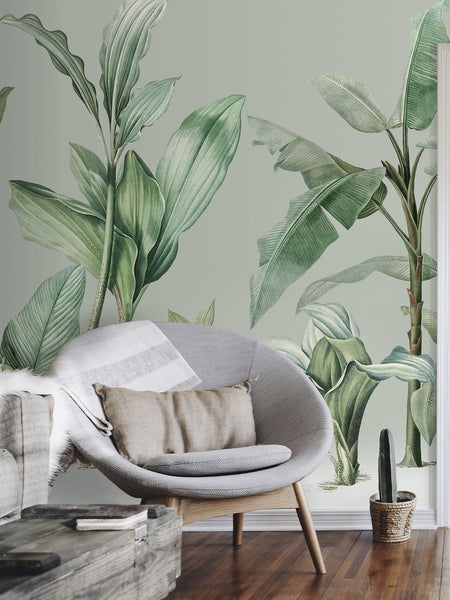 Raum mit illustrierter Blättertapete, Sessel und Holzboden