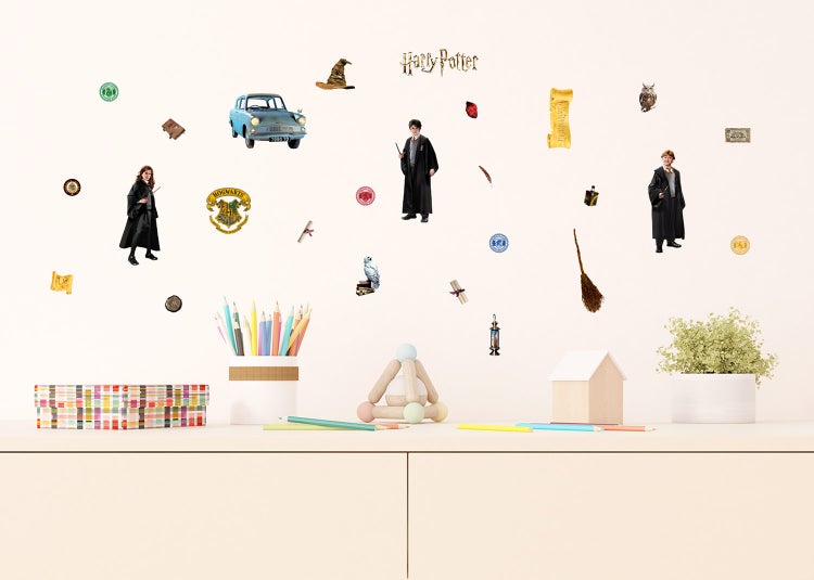 Harry Potter Wandsticker-Set mit Charakteren und magischen Motiven über einem Sideboard in einem Kinderzimmer.