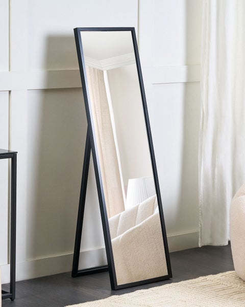 Freistehender Spiegel mit schwarzem Rahmen und reflektierender Oberfläche, der ein helles Interieur zeigt.