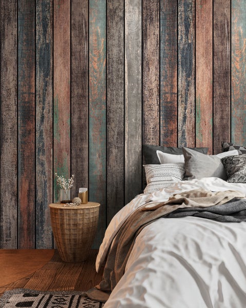 Wandgestaltung in Holzoptik mit mehrfarbigen Planken im Vintage-Stil, Schlafzimmer mit Bett, geflochtenem Nachttisch und Holzboden.