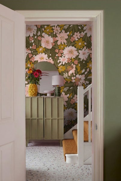 Einladender Flur mit blumiger Tapete, Kommode, Spiegel und Treppe
