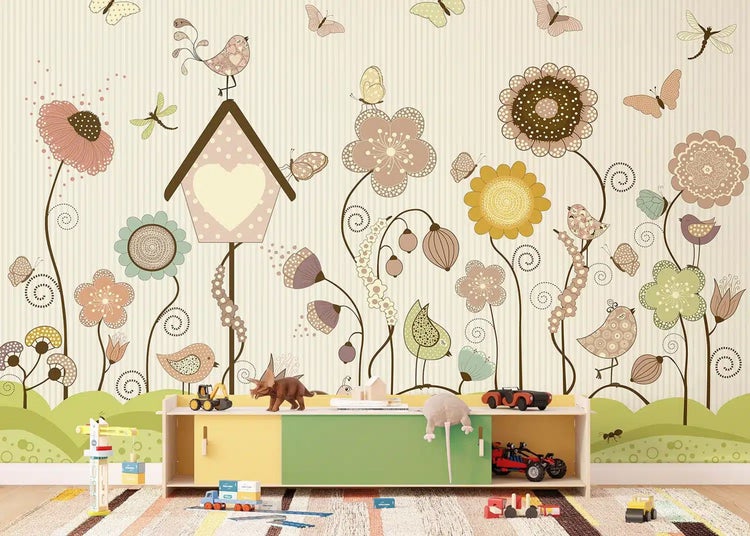 Verspielte Kinder-Fototapete mit Blumen, Vögeln, Schmetterlingen und Vogelhaus. Davor ein Regal mit Spielzeug in einem hellen Kinderzimmer.
