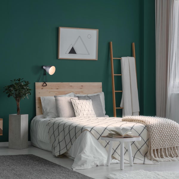 Helles Schlafzimmer mit Holzbett, Leiter und dekorativen Textilien für eine gemütliche Atmosphäre.