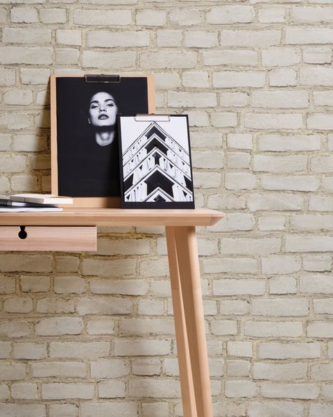 Wohnszene mit Schreibtisch, Stuhl, Lampe und Tapete im Stein-Design