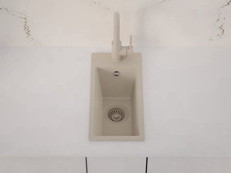 Einbauspüle aus Granitverbundstoff in Beige mit passender Armatur in einer modernen, hellen Küche.